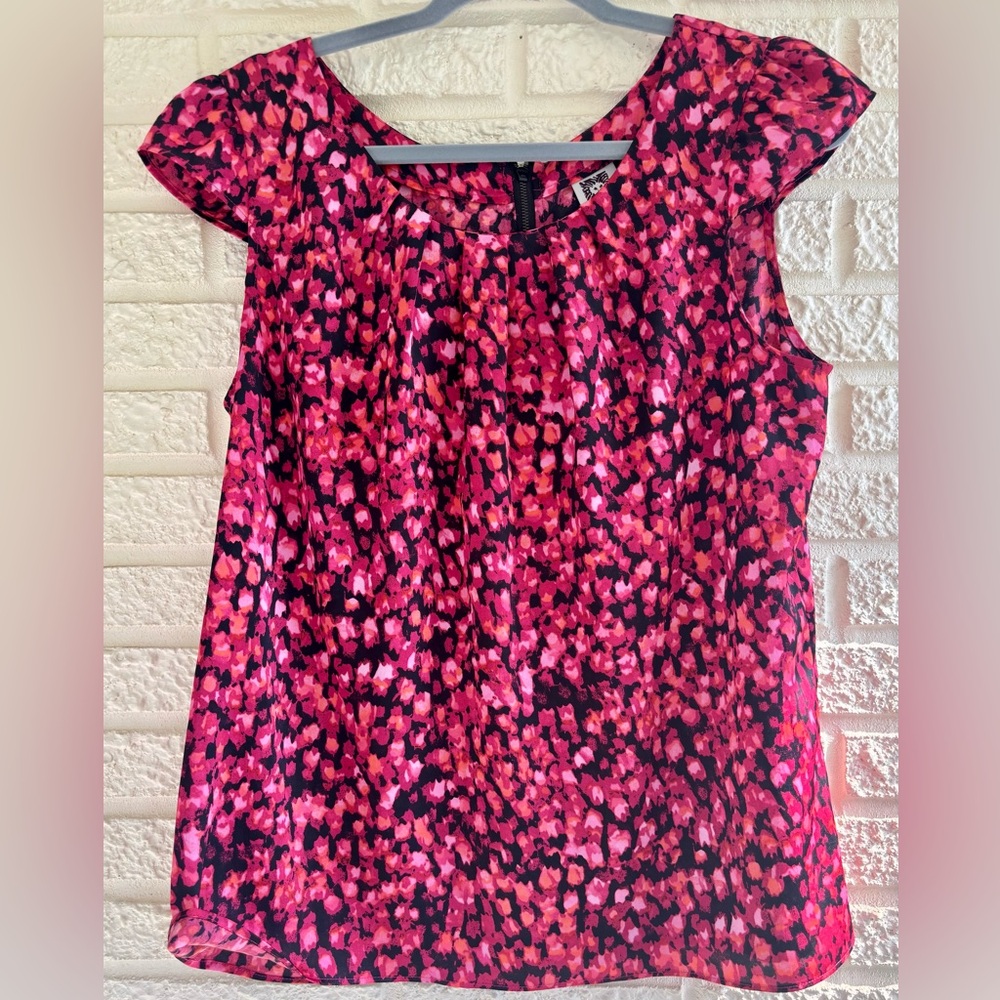 Anne Klein pink floral silk woman’s cap sleeve blouse with decorative zipper.